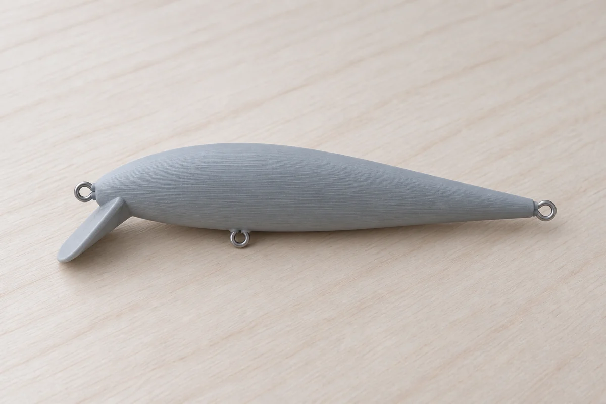 Illustration of an unpainted minnow resting on its side, with a medium diving lip and stainless wire eyes